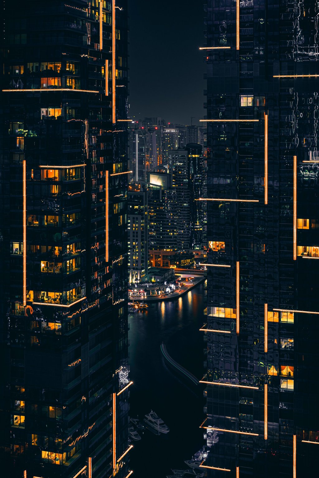 Buildings during nighttime with orange lighting and water below